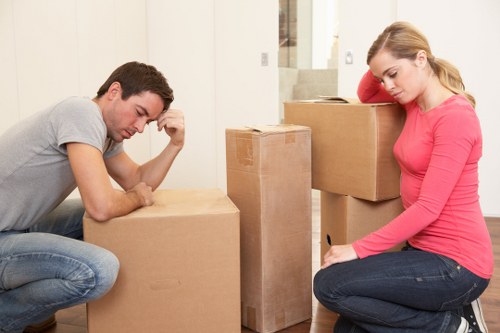 Mover carrying furniture while wearing PPE and using safe lifting technique
